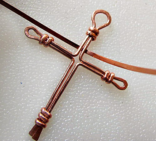 Place the center of the half round wire behind the cross, flat side facing you